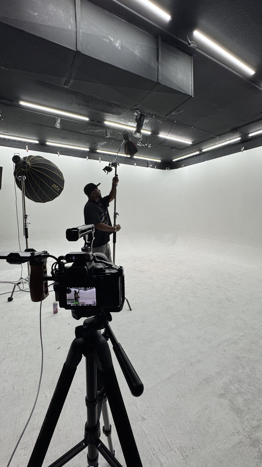 Camera on a tripod in a white photo studio during a shoot